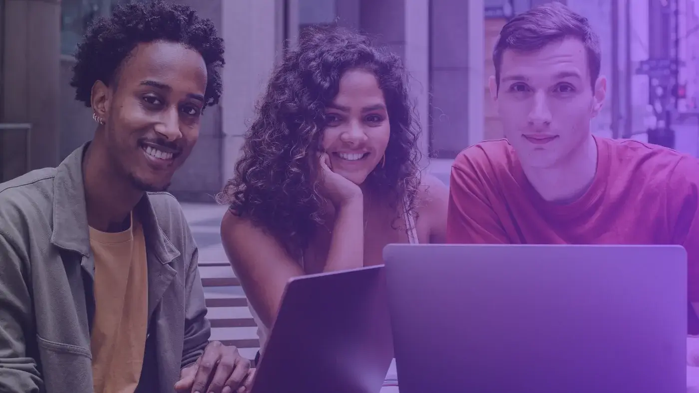 Trois jeunes souriants devant leur ordinateur, prêts à candidater en BTS MCO
